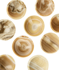 Aragonite ritual bowls seen from above, veined with cream, beige and brown
