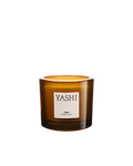 Yashi Murmure d'Aura candle in amber glass, cream label, on a light background