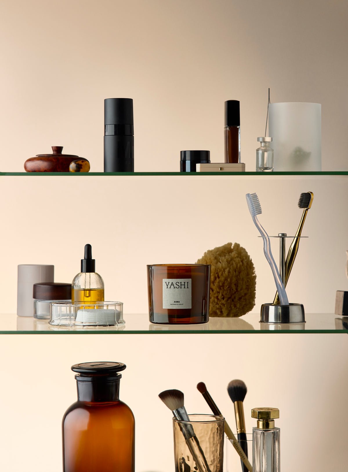 Murmure d'Aura on a bathroom shelf, among bottles, a sponge and toothbrushes